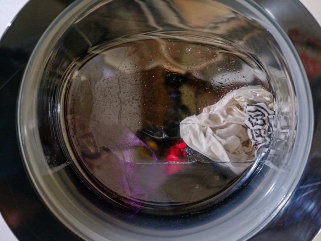 Binnenkant van de trommel van een wasmachine met kleren erin